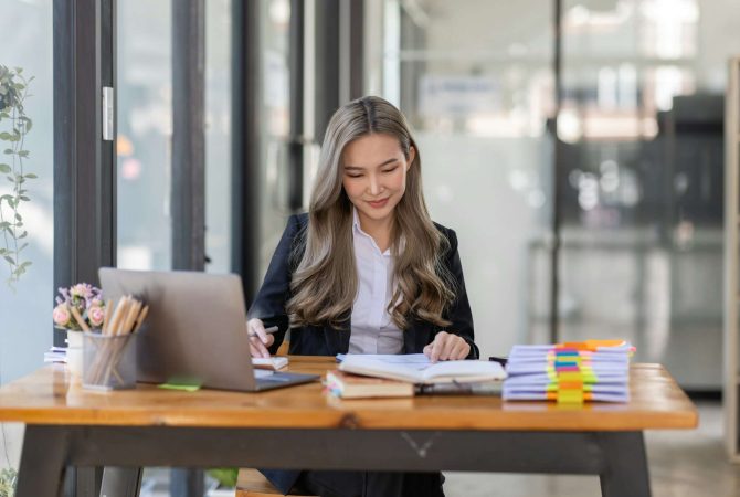 business Asian woman or accountant Bookkeeper working on calculator to calculate business data,