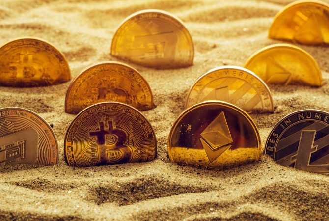 Cryptocurrency coins in sand