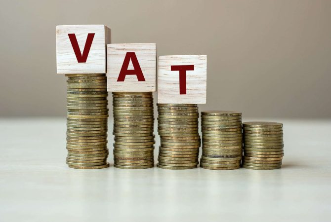 VAT wooden cube with golden coin on growing money stairs
